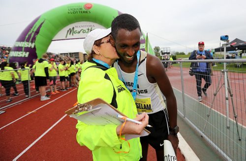 TREVOR HAGAN / WINNIPEG FREE PRESS Participating in her 38th Manitoba Marathon, Marilyn "Mouse" Faser, congratulates half marathon winner Abdusalem Yussuf after crossing the finish line, Sunday, June 19, 2016.