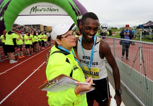 TREVOR HAGAN / WINNIPEG FREE PRESS Participating in her 38th Manitoba Marathon, Marilyn "Mouse" Faser, congratulates half marathon winner Abdusalem Yussuf after crossing the finish line, Sunday, June 19, 2016.