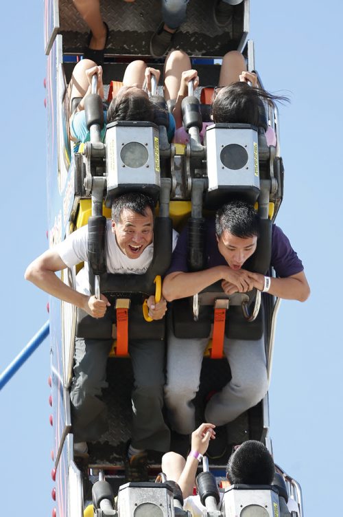 JOHN WOODS / WINNIPEG FREE PRESS Ming Yan (L) and his friend Ye Tian have fun on the Fire Ball at the Red River Ex Sunday, June 19, 2016.