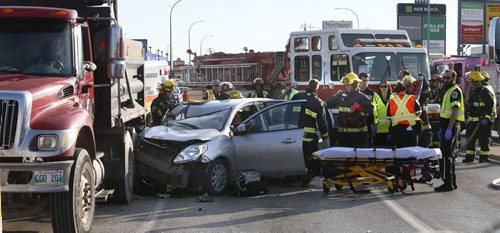 WAYNE GLOWACKI / WINNIPEG FREE PRESS       Winnipeg Fire Paramedics at the scene of a collision involving a car and a dump truck on McPhillips St. and Inkster Blvd. Tuesday morning. At least two occupants in car were injured. June 21  2016