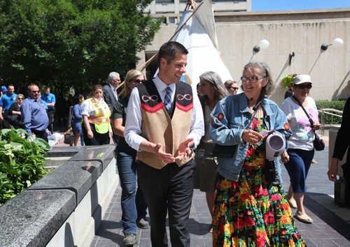 RUTH BONNEVILLE / WINNIPEG FREE PRESS  Mayor Brian Bowman takes part in Celebrating National  Aboriginal Day with formal speeches, Traditional Metis Dancing and planting cedar trees and sage plants with spiritual teacher, Carolyn Moar Tuesday.  This year had a   special honour being 2016 Year of Reconciliation.  Mayor Bowman and Moar (right) chat while heading to planting ceremony.    June 21 / 2016