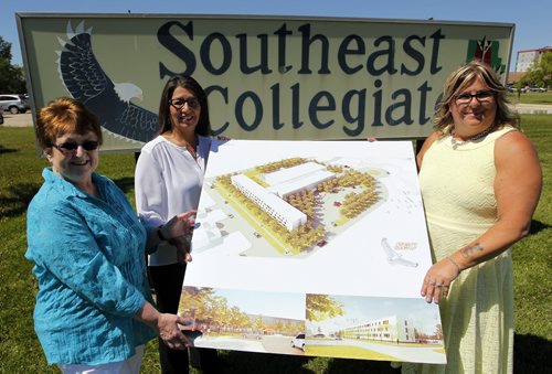 BORIS MINKEVICH / WINNIPEG FREE PRESS (left-right) Ellen Young, chairperson of the Southeast board of directors, Sheryl McCorrister, school principal, and Marlene Waterston, director of operations pose for a photo in front of the old sign with the new drawings of the school that is going to be built on the Lee Blvd location. June 21, 2016.