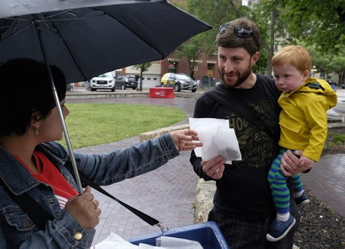 ZACHARY PRONG / WINNIPEG FREE PRESS  Amanda Connolly of United Way hands Chris Galipeault and his son Sebastian, 1, a cookie as part of United Way's Conscious Kindness campaign on June 22, 2016.