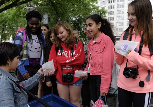 ZACHARY PRONG / WINNIPEG FREE PRESS  Amanda Connolly of United Way hands cookies to Acadia Junior High School students at Old Market Square on June 22, 2016. From left to right, Ini Odimayomi, Tia Pollen, Enti Sadik and Natalia Kalichak.