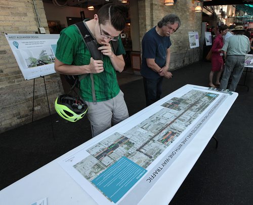 PHIL HOSSACK / WINNIPEG FREE PRESS -  Cyclist Evan Proulx (left in green) gets a close look at maps  of proposed downtown bike lanes Thursday at an open house held at the Forks to get input from Winnipeggers. See Ashley Prest story. - See story. June 23, 2016