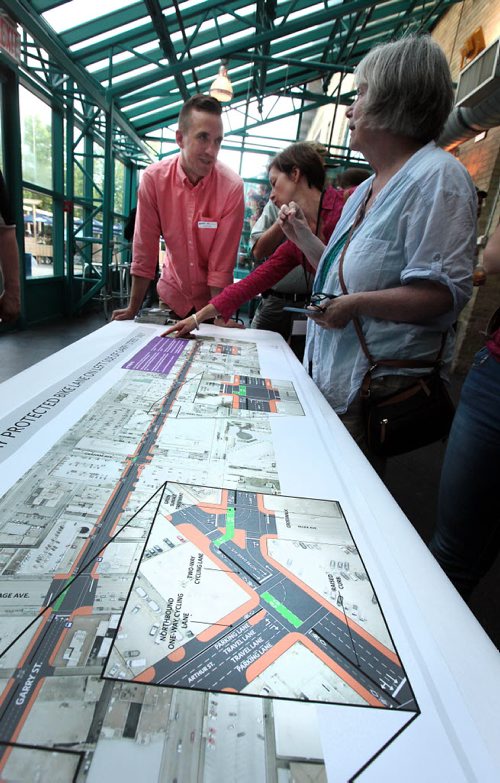 PHIL HOSSACK / WINNIPEG FREE PRESS -  Cyclists and city officials take a close look at maps of proposed downtown bike lanes Thursday at an open house held at the Forks to get input from Winnipeggers. See Ashley Prest story. - See story. June 23, 2016