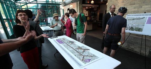 PHIL HOSSACK / WINNIPEG FREE PRESS -  Cyclist Evan Proulx (centre in green) gets a close lookat maps  of proposed downtown bike lanes Thursday at an open house held at the Forks to get input from Winnipeggers. See Ashley Prest story. - See story. June 23, 2016