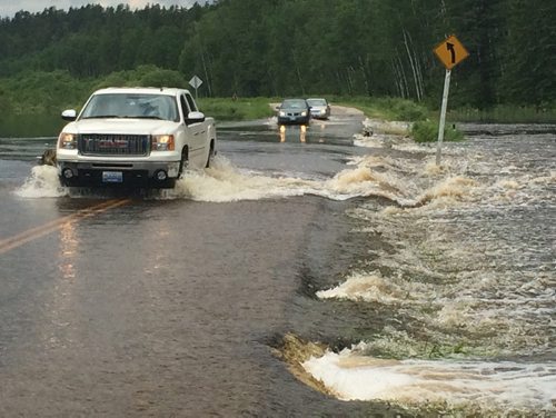 JOE BRYKSA / WINNIPEG FREE PRESS Cars drive through flood waters on hyw 44 near Caddy lake Saturday. June 25, 2016