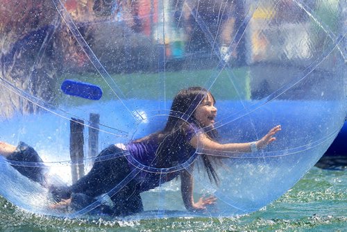 RUTH BONNEVILLE / WINNIPEG FREE PRESS  Seven-year-old Miah Frampton tries to walk on the water in the Wobbly Water Ball at the Red River Ex Saturday. Standup photo  June 25 / 2016