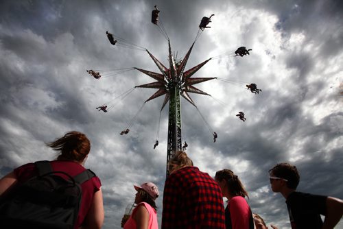 RUTH BONNEVILLE / WINNIPEG FREE PRESS  People wait in line to have their turn on the Swing Tower while others fly through the sky at the Red River Ex Saturday. Standup photo  June 25 / 2016