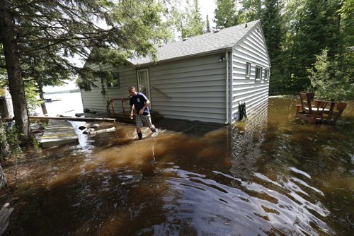 WAYNE GLOWACKI / WINNIPEG FREE PRESS  Water from a flooded Caddy Lake surrounds Keith Dixon's beach house Monday.  Bill Redekop Story June 27  2016