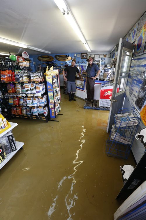 WAYNE GLOWACKI / WINNIPEG FREE PRESS  At right, Alec Young and his son Ian in their flooded store in the  Faloma Beach Marina along Falcon Lake Monday. Bill Redekop Story June 27  2016