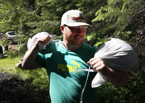 WAYNE GLOWACKI / WINNIPEG FREE PRESS  Jason Fehr carries sand bags for his cottage along Caddy Lake Monday.  Bill Redekop Story June 27  2016