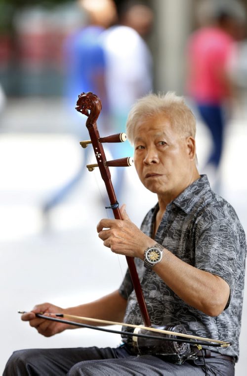 WAYNE GLOWACKI / WINNIPEG FREE PRESS  Musong Tan from China doesn't speak a word of english, only communicating with passersby with his erhu sending beautiful calm music through the Portage Ave. Carlton St. intersection Wednesday. The Erhu is a  Chinese 2-string violin type of musical instrument that dates back over 4000 years. June 29  2016