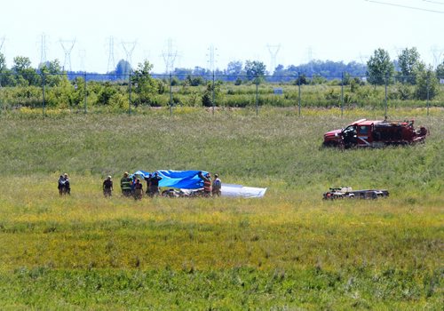 Ruth Bonneville / Winnipeg Free Press   Rescue crews cover the cockpit of a small plane that crashed just north of Number one highway, east of the floodway Friday morning.  It took off from Lyncrest Airport earlier in the day with two people on board.  Both are presumed to have died in the crash.  No other details are available at this time.      July 01/2016