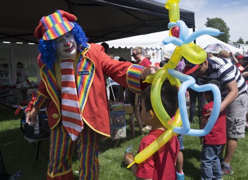 ZACHARY PRONG / WINNIPEG FREE PRESS  Mr. Squiggly makes a balloon dragon for R.G. Deal Cruz, 6, at Assiniboine Park. July 1, 2016.