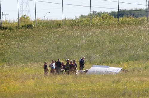 Ruth Bonneville / Winnipeg Free Press   Rescue crews stand next to a small plane that crashed just north of number one highway, east of the floodway Friday morning.  It took off from Lyncrest Airport earlier in the day with two people on board.  Both are presumed to have died in the crash.  No other details are available at this time.      July 01/2016