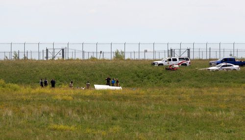Ruth Bonneville / Winnipeg Free Press   Investigators look over a small plane that crashed just north of Number one highway, east of the floodway Friday morning.  It took off from Lyncrest Airport earlier in the day with two people on board.  Both are presumed to have died in the crash.  No other details are available at this time.      July 01/2016