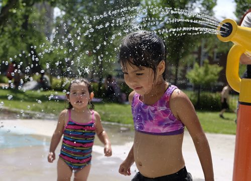 ZACHARY PRONG / WINNIPEG FREE PRESS  Meadow, 4, and her sister Jazmine, 2, cool off at the splash park on Cumberland on July 2, 2016.