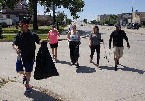 ZACHARY PRONG / WINNIPEG FREE PRESS  Participants in the Village Walk, a community event that takes place every Monday throughout the summer, pick up garbage as they stroll through Winnipeg's North End. The Village Walk was founded by Jade Harper in the hopes of promoting fitness, building community and teaching people about the city's historic North End. From left to right, Chris Clacio, Pamela Leost, Jade Harper, Cory Gregorashuk, and Will Smith.