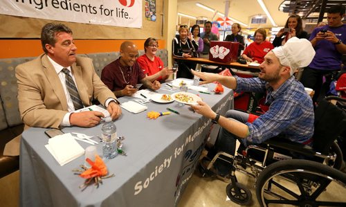 JASON HALSTEAD / WINNIPEG FREE PRESS  Drew Kozub (KISS 102.3) takes his dish to the judges at the Society for Manitobans with Disabilities (SMD)/Easter Seals Manitoba Celebrity Cook-Off for Kids competition during the 2016 Safeway Campaign Launch at Madison Square Safeway on June 29, 2016. Local media celebrities navigated a competition kitchen in wheelchairs to prepare camp-themed dishes for a panel of three judges. (See Social Page)