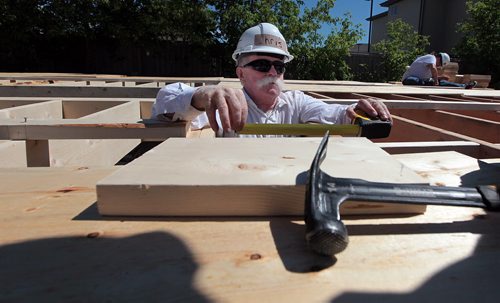 PHIL HOSSACK / WINNIPEG FREE PRESS - Measure twice, cut once.....Chris Pearce reads his tape measure carefully working on the latest Habitat for Humanity home. The St Vital interfaith project is building a "Ready To Move" home on the parking lot of the Evangelical Mennonite Church on St Mary's Road. See release/story?   . July 5, 2016