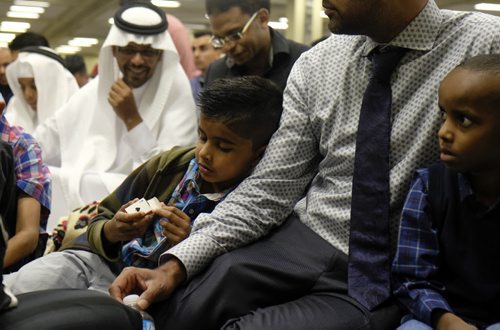 ZACHARY PRONG / WINNIPEG FREE PRESS  From left to right, Yunus Siddiqui, his father Omar and Ayub Galab Daud wait for prayers to begin at the RBC Convention Centre where thousands of people gathered for Eid celebrations. Eid marks the end of the Muslim holy month of Ramadam. July 6, 2016.