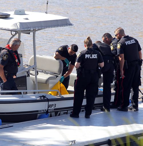 BORIS MINKEVICH / WINNIPEG FREE PRESS Police with yellow body bag in Police boat at St. Vital Park boat launch.  July 6, 2016