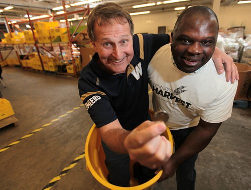 PHIL HOSSACK / WINNIPEG FREE PRESS - Winnipeg Harvest's David Northcott and Winnipeg Blue Bomber Hall of Famer James Murphy pose with a bin and a toonie Thursday to kick off 30K for 30YRS campaign from July 7-14 is asking fans to bring a toonie to the July 14 game hoping to raise $30,000 to celebrate the 30 year anniversary of the relationship between the Bombers and Harvest. See story. July 7, 2016