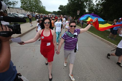 RUTH BONNEVILLE / WINNIPEG FREE PRESS  Michelle McHale and her partner Karen Phillips hold hands as they lead thousands of supporters down the streets of Steinbach on their way to city hall to celebrate Steinbach's 1st ever Pride march Saturday.   July 09, 2016