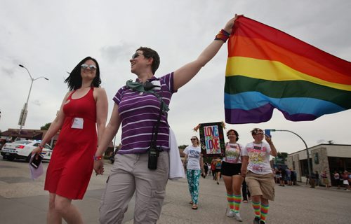 RUTH BONNEVILLE / WINNIPEG FREE PRESS  Michelle McHale and her partner Karen Phillips hold hands as they lead thousands of supporters down the streets of Steinbach on their way to city hall to celebrate Steinbach's 1st ever Pride march Saturday.   July 09, 2016