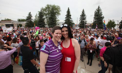 RUTH BONNEVILLE / WINNIPEG FREE PRESS  Michelle McHale and her partner Karen Phillips stand on the steps city hall in Steinbach as thousands of supporters gather behind them at to celebrate Steinbach's 1st ever Pride march Saturday.   July 09, 2016