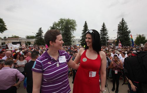 RUTH BONNEVILLE / WINNIPEG FREE PRESS  Michelle McHale and her partner Karen Phillips stand on the steps city hall in Steinbach as thousands of supporters gather behind them at to celebrate Steinbach's 1st ever Pride march Saturday.   July 09, 2016