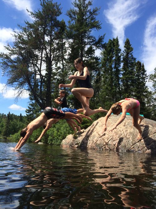 BORIS MINKEVICH / WINNIPEG FREE PRESS JUMPING INTO SUMMER - Some kids from Winnipeg enjoy summer weather by jumping off a rock into deep water at Rushing River Provincial Park, just east of Kenora, Ontario.  Weather in Ontario was sunny all three days with a bit of rain for a few hours. The group meets at the popular camping spot every year to kick off summer holidays. July 10, 2016
