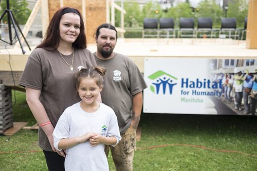 ZACHARY PRONG / WINNIPEG FREE PRESS  Sasha Ward, Kyle Warren and their daughter Hailey Warren, 7, in front of what will soon be their new home built by Habitat for Humanity. The home will be built over two weeks with volunteers from the University of Winnipeg, Canadian Institute of Plumbing and Heating, Investors Group and Sustainable Forestry Initiative. July 11, 2016.