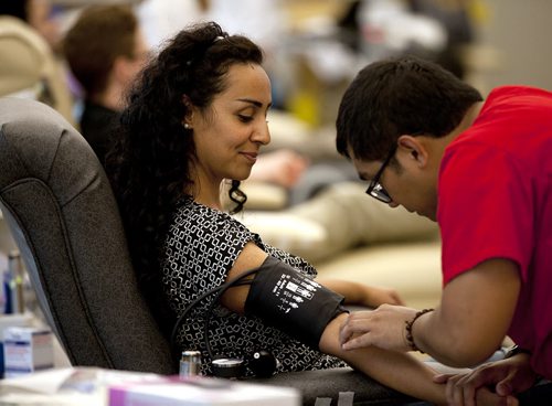 PHIL HOSSACK / WINNIPEG FREE PRESS - Shlar Ali, watches as Phlebotomist, Dan Caballero searches for just the right vein to puncture. Shlar and other members of the Syrian Community took time to volunteer blood donations at the Canadian Blood Services Monday evning. See Carol Sanders story. July 11, 2016