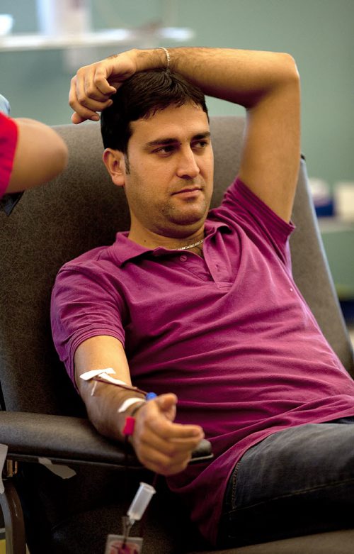 PHIL HOSSACK / WINNIPEG FREE PRESS - Karwan Kahil relaxes while donating Blood for the first time in Canada. His first donation was in Syria to help his father through open heart surgery. Karwan  and other members of the Syrian Community took time to volunteer blood donations at the Canadian Blood Services Monday evning. See Carol Sanders story. July 11, 2016