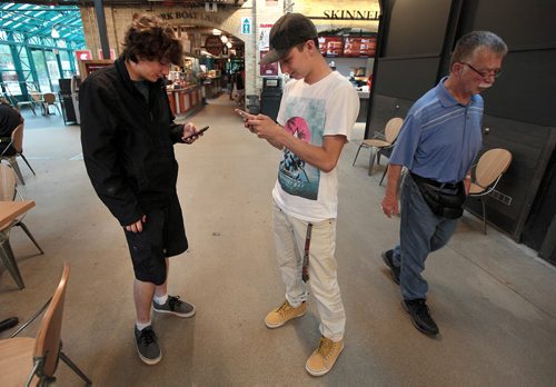 PHIL HOSSACK / WINNIPEG FREE PRESS - Luke Geisbrecht (left) and David Clarke were found inside the Forks Market following their smart phones and tracking Pokemon. Totally oblivious to the large gathering of Pokemon hunters just outside at a "Meet Up" See Alex dePape's story. July 11, 2016