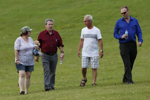 JOHN WOODS / WINNIPEG FREE PRESS After releasing a lantern, family and friends walk down a hill with Robert Krull (2nd left), the husband of Thelma Krull, during a vigil for Thelma at Civic Park Monday, July 11, 2016.