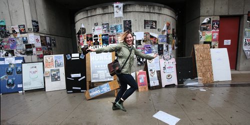 PHIL HOSSACK / WINNIPEG FREE PRESS -  Kerry Ipema, a first-time Fringe performer from New York runs through the rain past fringe posters at MTC Wednesday. See Melissa Martin Story.    July 13, 2016