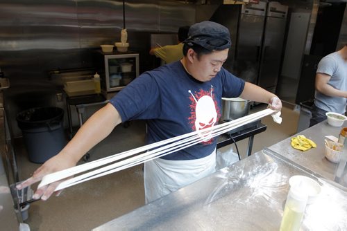 BORIS MINKEVICH / WINNIPEG FREE PRESS NEXT Dancing Noodle. Chef Xiaofei Zuo pulls  fresh noodles for a dish. Winnipeg Free Press's Ben MacPhee-Sigurdson tests out some beer at The Common located in The Forks. July 12, 2016