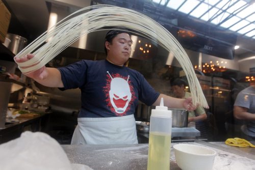 BORIS MINKEVICH / WINNIPEG FREE PRESS NEXT Dancing Noodle. Chef Xiaofei Zuo pulls  fresh noodles for a dish. Winnipeg Free Press's Ben MacPhee-Sigurdson tests out some beer at The Common located in The Forks. July 12, 2016