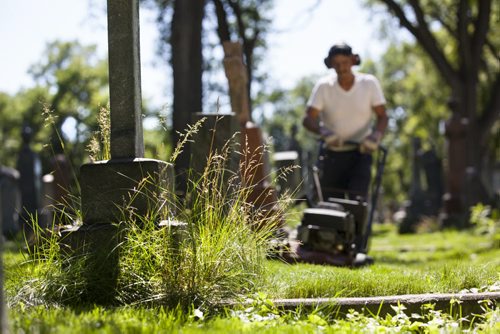 RUTH BONNEVILLE / WINNIPEG FREE PRESS  The Cathedral Church of Saint John grounds keeper, Dennis Bealieu, works his way around the headstones and uneven ground to mow the lawn in the historic cemetery Friday.    July 15, 2016