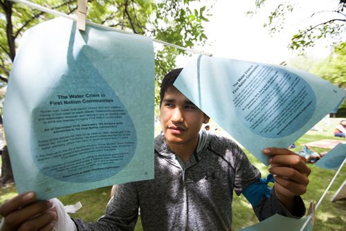 RUTH BONNEVILLE / WINNIPEG FREE PRESS  Sixteen-year-old Rainer Bunn From Shoal Lake 40 First Nation shares his thoughts and concerns about what it's like living without running water on his reserve holding art installation at Steven Juba Park Saturday.  13 Fires Winnipeg, Shoal Lake residents and friends take part in discussing the water issues facing the reserve at Steven Juba Park along the Red River Saturday.   See Alex Paul story.   July 16, 2016