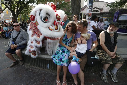 JOHN WOODS / WINNIPEG FREE PRESS Joanna and Orlando Braun with their daughter Willow are surprised by the Causin a Commotion chinese lion at the Winnipeg Fringe Festival Sunday, July 17, 2016.