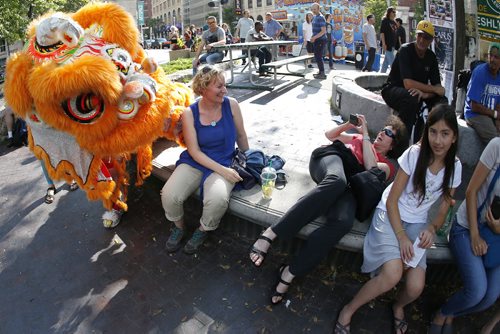 JOHN WOODS / WINNIPEG FREE PRESS Denise Lecuyer takes a photo of her friend Christelle Dorn and the Causin a Commotion chinese lion at the Winnipeg Fringe Festival Sunday, July 17, 2016.