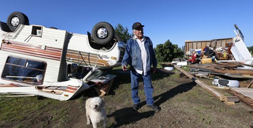 WAYNE GLOWACKI / WINNIPEG FREE PRESS Clemance Assiniboine with his dog Baby in the back yard of his home on the Long Plain First Nation where sheds at right, his house and motor home were damaged after a tornado touched down Wednesday night. Ashley Prest story July 21 2016