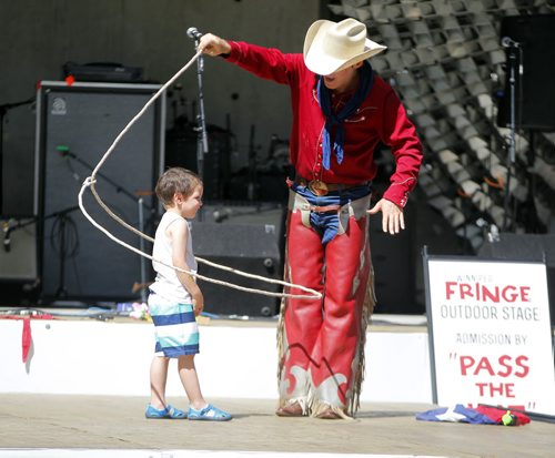 BORIS MINKEVICH / WINNIPEG FREE PRESS FRINGE STANDUP WEATHER - Right, Shelby Bond/Cowboy Max from Los Angeles, California performs in front of the Cube at Old Market Square. His other show is at Venue 26 is called The Beguiling Buffoonery of Jim Chiminey.  In this photo 4 year old Sal Pellettieri, left,  of Winnipeg, Manitoba participates in his act under the hot sun. July 21, 2016