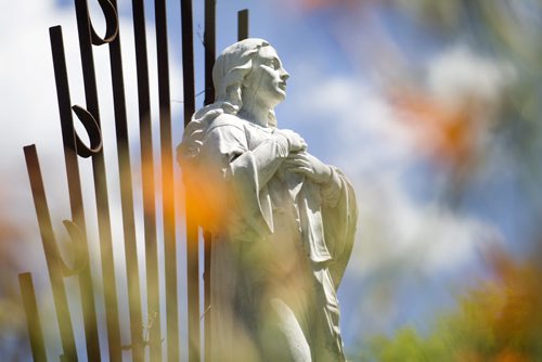 RUTH BONNEVILLE / WINNIPEG FREE PRESS  Statue of Mary through summer flowers.   See Bill Redekop's story on St. Boniface Cemetery.     July 21, 2016