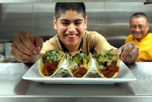 BORIS MINKEVICH / WINNIPEG FREE PRESS RESTAURANT REVIEW -  La Roca. 155 Smith Street. Mexican food.  This photo cook Edwin Quintanilla , left, presenting some Pastor Tacos.  On right in background is executive chef Franklin Quintanilla, Edwin's dad. July 21, 2016